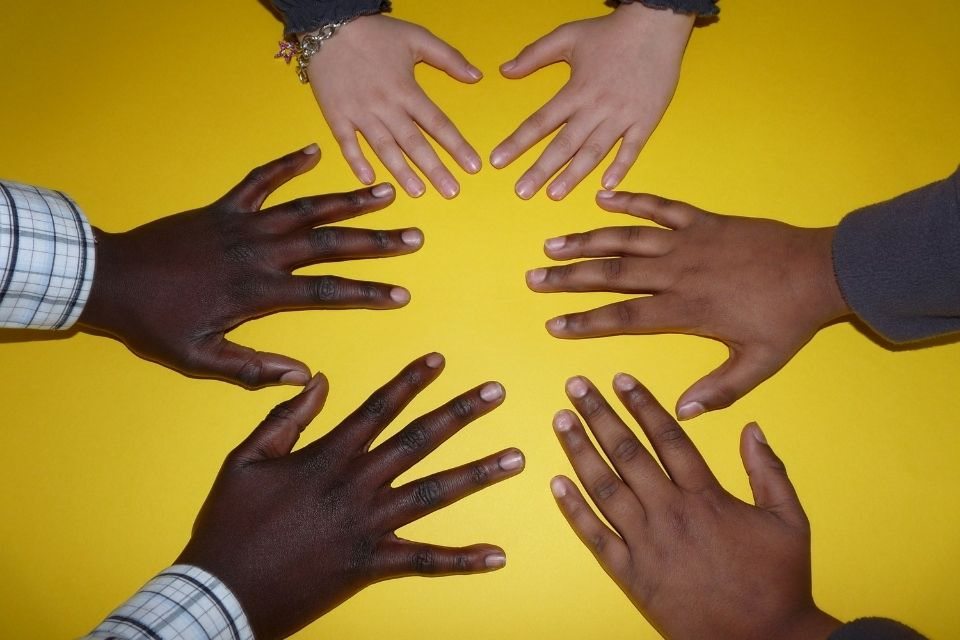 Hands of different races reaching out