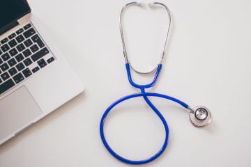 stethoscope next to a laptop